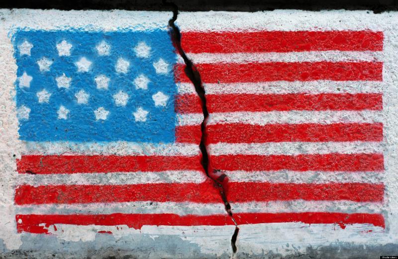 Painting of the american flag on concrete, a large crack splits the flag in two